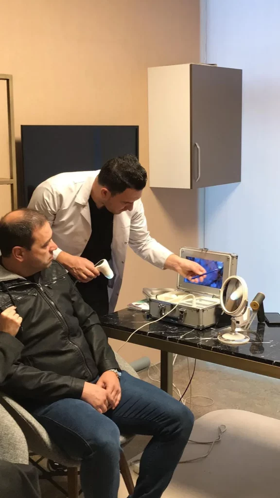 Dr Kinyas explaining the patient about his hair quality before undergoing hair transplant in turkey Dr Kinyas explaining the patient about his hair quality before undergoing hair transplant in turkey