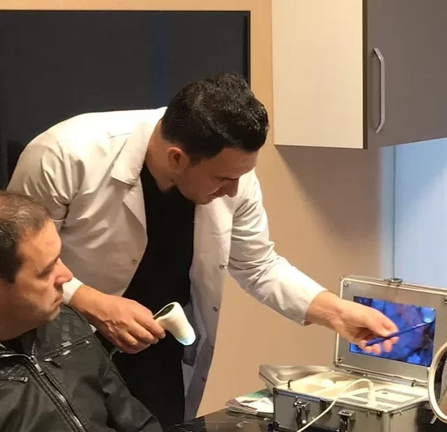 Dr Kinyas explaining the patient about his hair quality before undergoing hair transplant in turkey